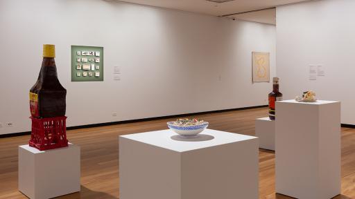 A gallery space with several sculptures displayed on white pedestals.