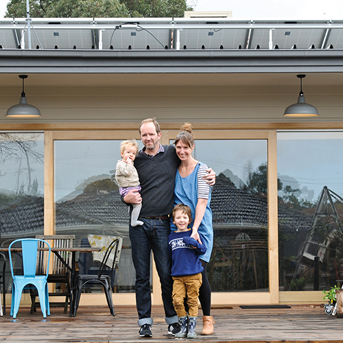 Young family standing in front of home