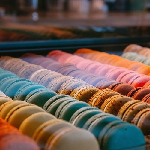 A display of macarons, arranged by colour order.