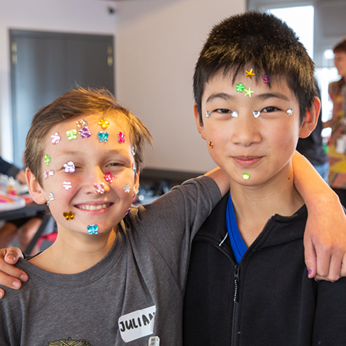 Two young boys whose faces covered in sequins.