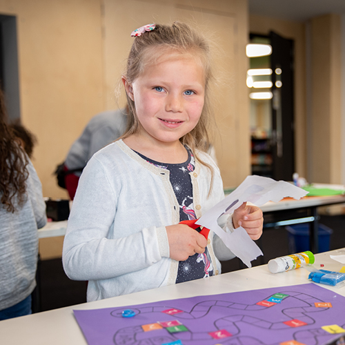 Young girl doing a craft activity with coloured paper.