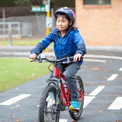 Child riding a bike on the track at Kew Traffic School.