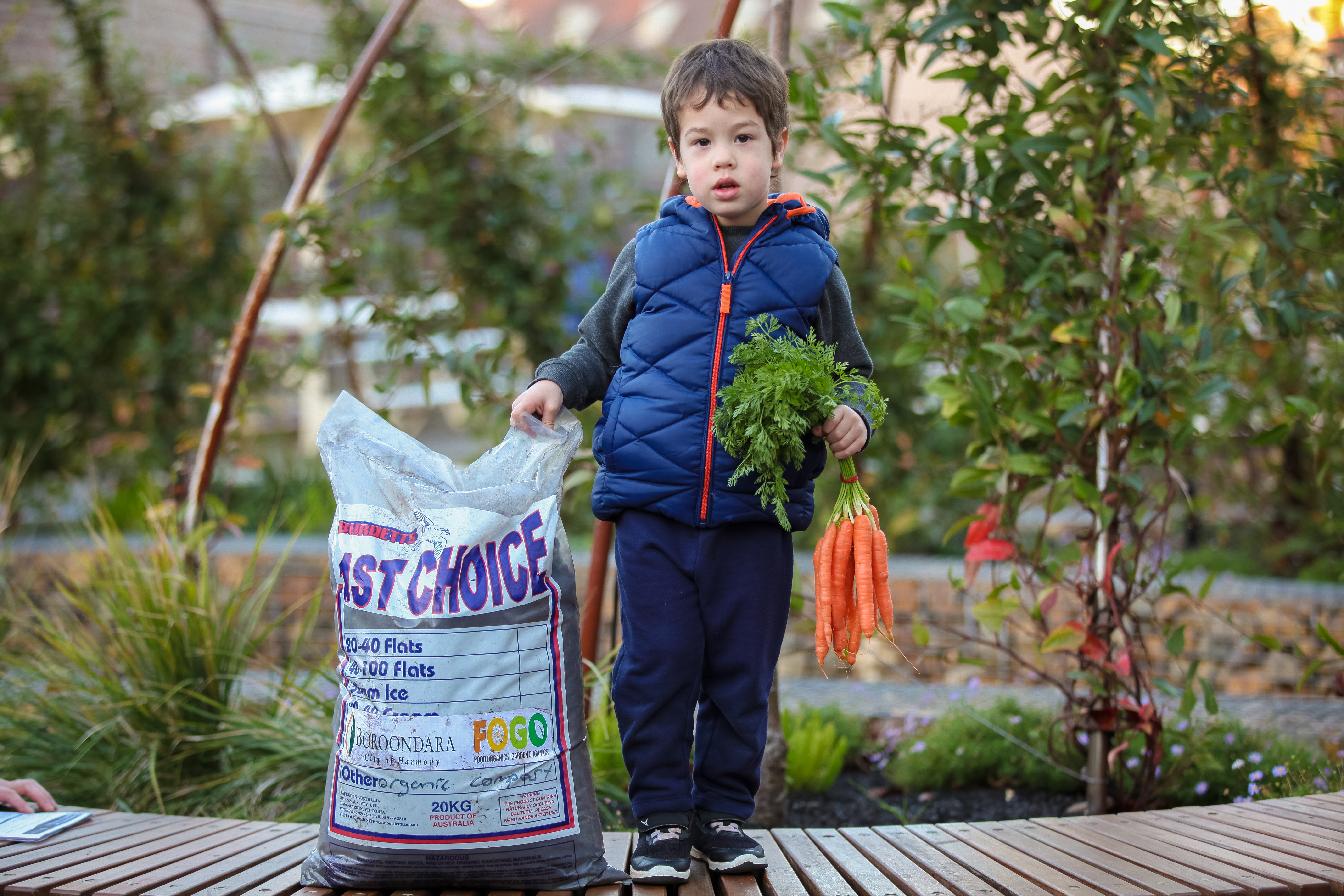 A boy standing next to FOGO compost