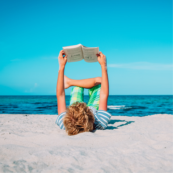 a child reading on a beach