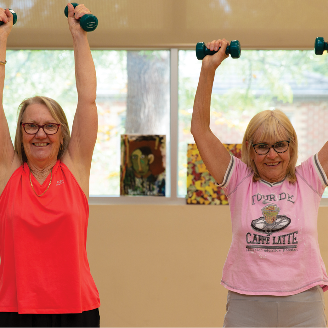 women holding weights above their heads
