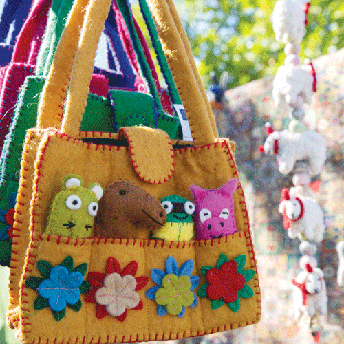 A selection of colourful felt bags with pockets on the front holding felt animals