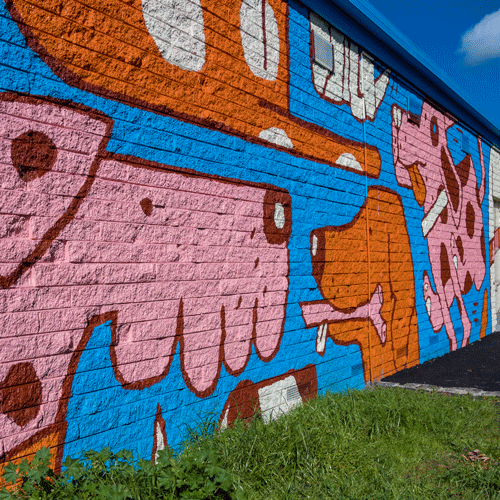 Mural of stylised dogs running and playing