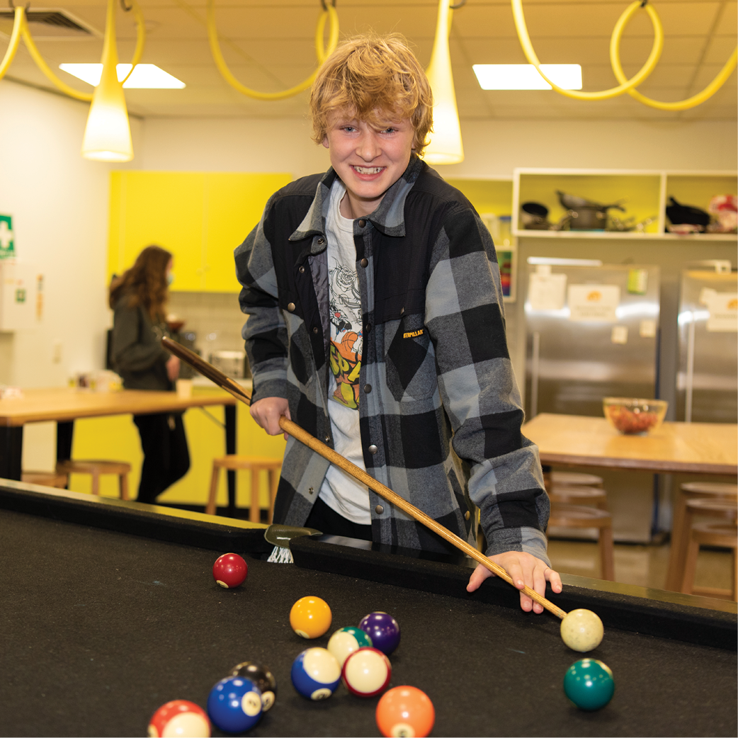 A young person playing pool