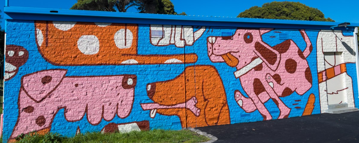 a building wall painted with images of dogs sitting and playing