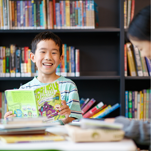 A child reading a book in a library