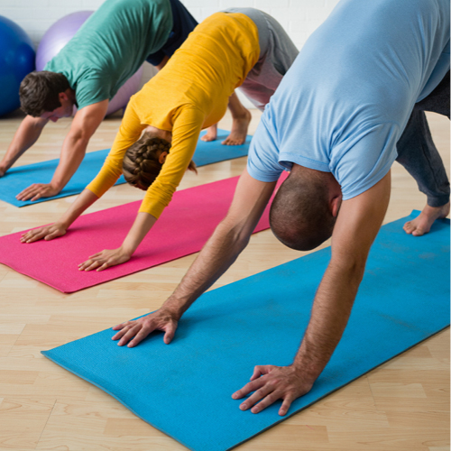 Three people doing yoga, each on their own brightly coloured exercise mat