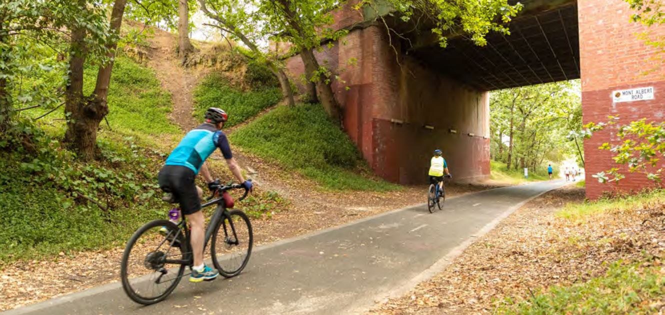 Two people riding their bikes along an off-road trail