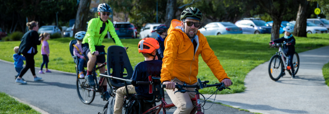 A group of people riding their bikes on a path