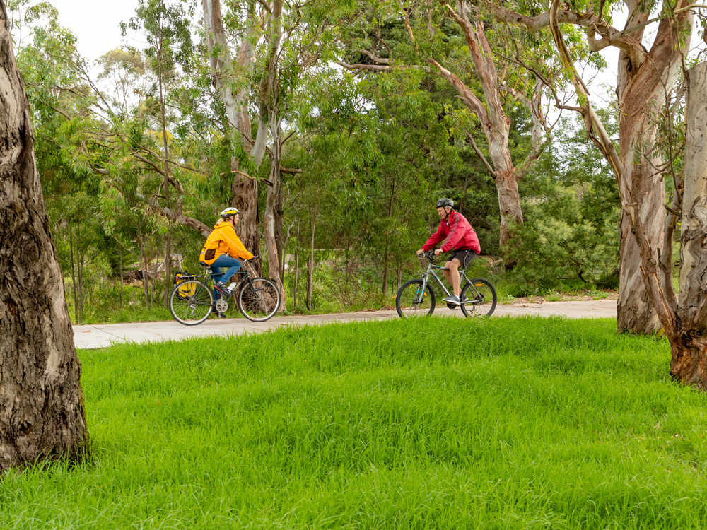 2 people riding on a creek trail