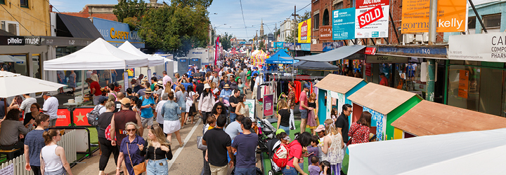 bustling street festival with canopies, tents and crowds of people