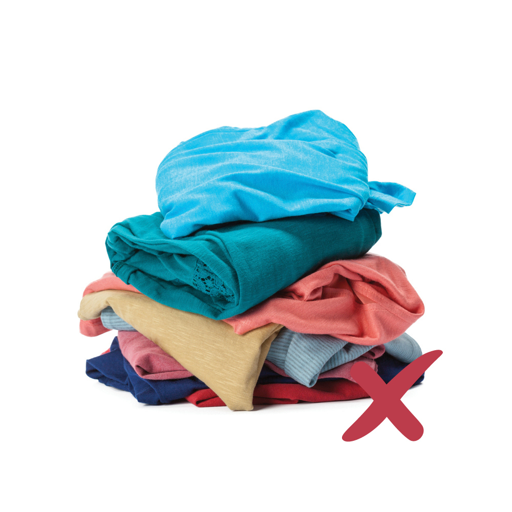 A pile of folded clothes and fabrics with a red cross on them