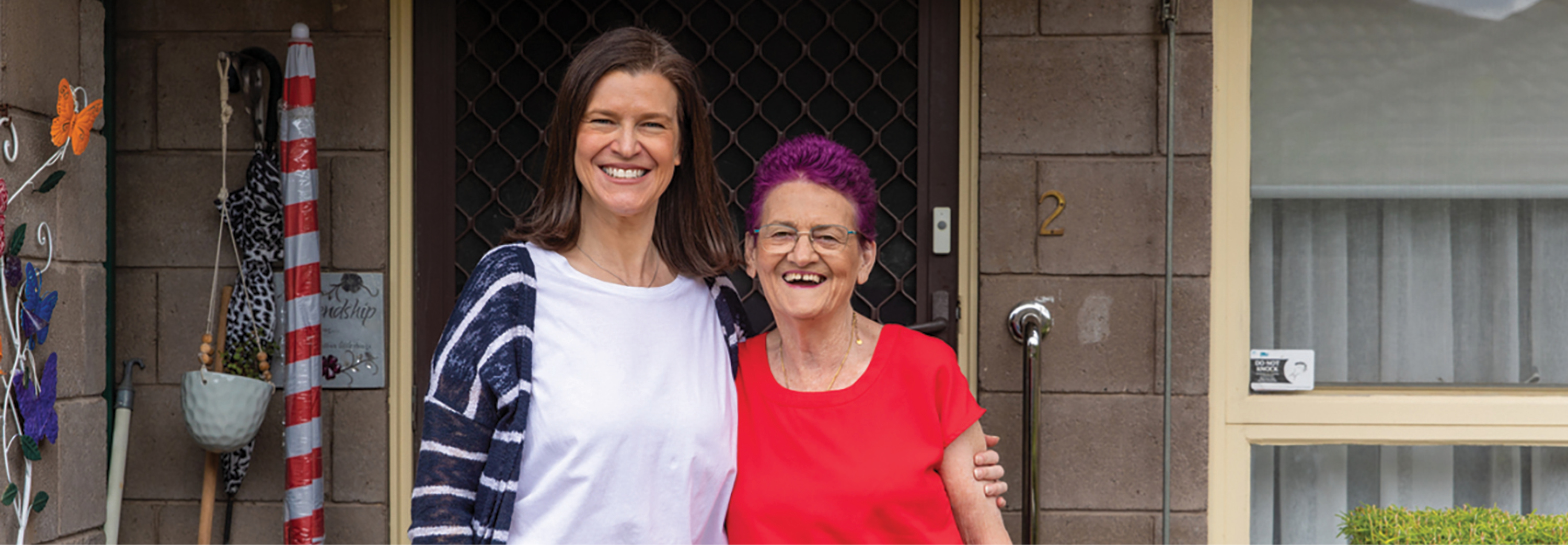 2 women smiling outside their front door