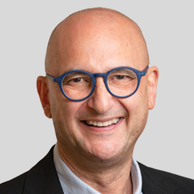 Councillor Victor Franco smiling and wearing a black suit and blue glasses