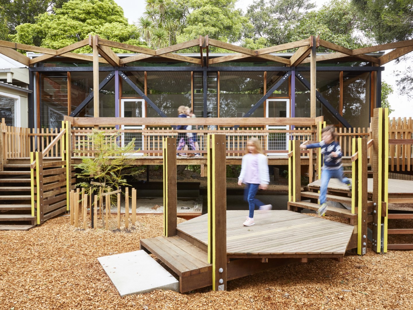 Children running down stairs to play at a modern kindergarten outdoor area