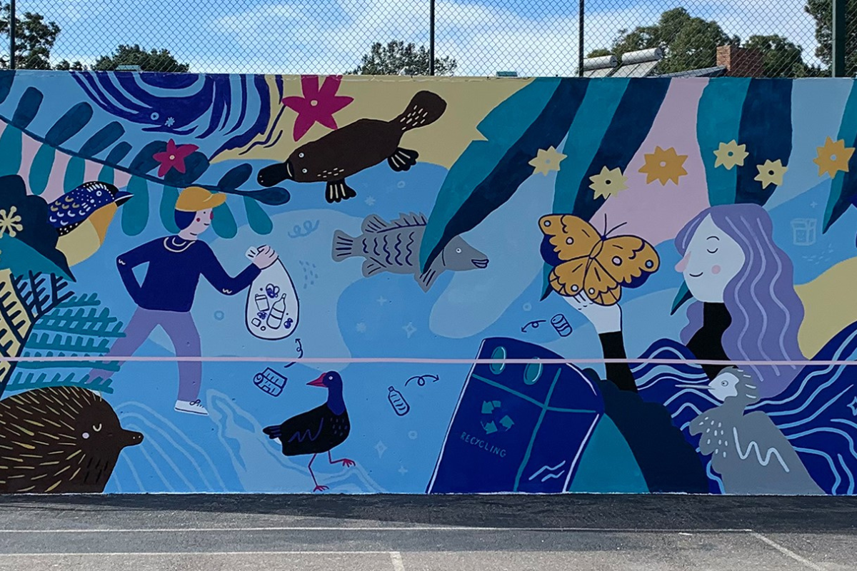 A mural on a rebound wall showing a person with a butterfly on their hand and another person holding a bag of rubbish, both are surrounded by colourful flowers, plants and animals