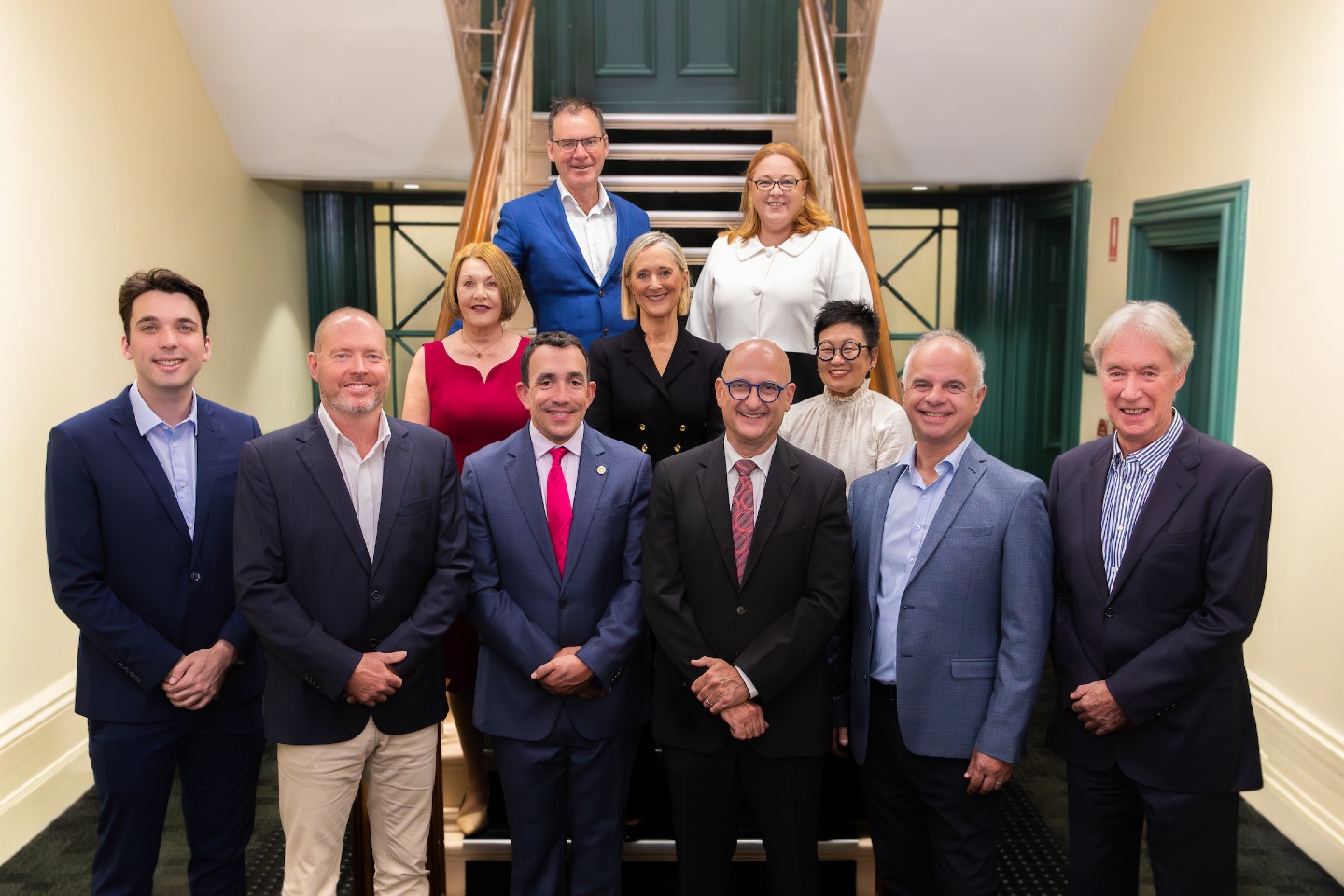 Council members posing for a group photo in Council office on stairs.