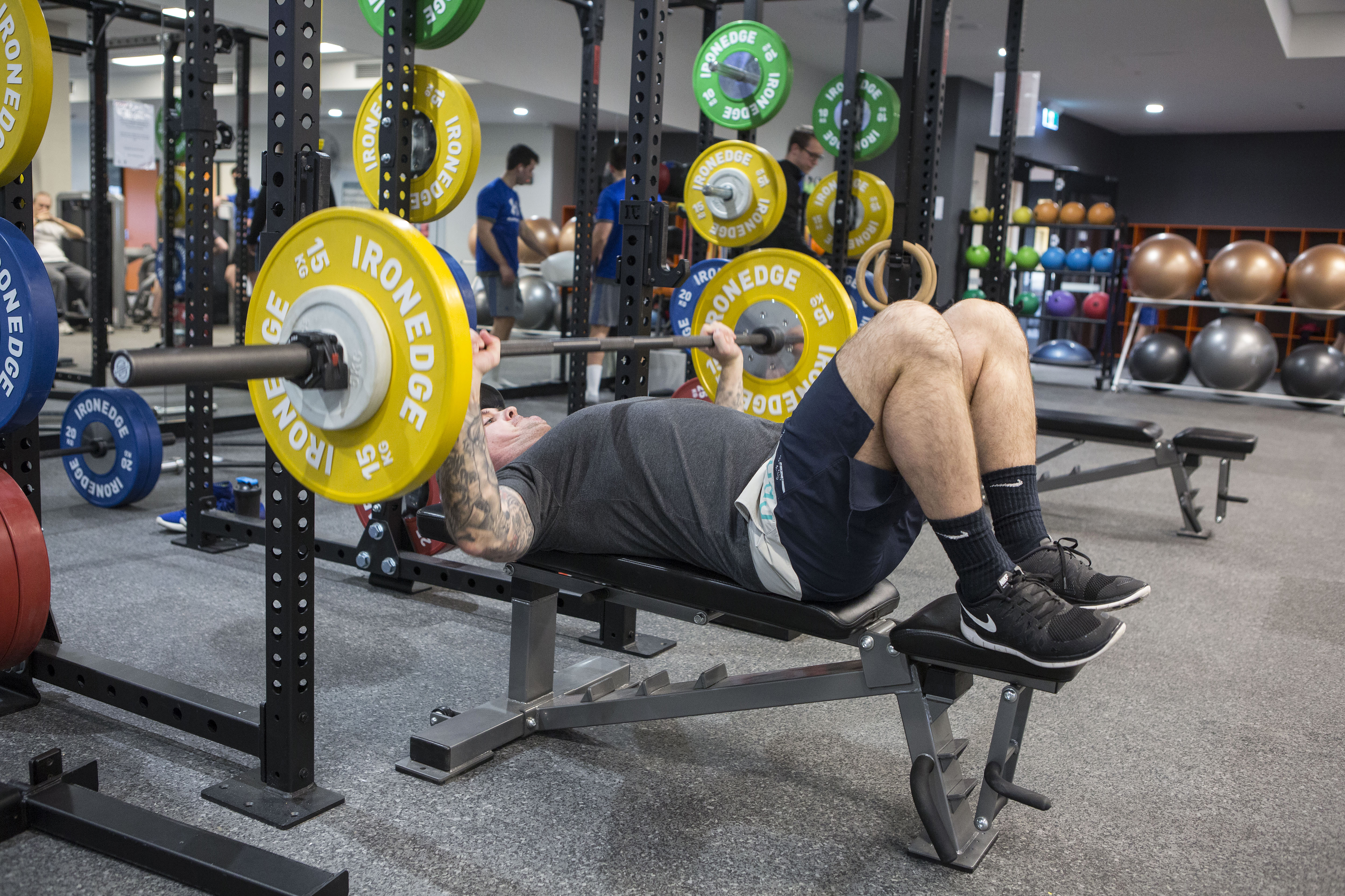 a man bench presses a heavy barbell 