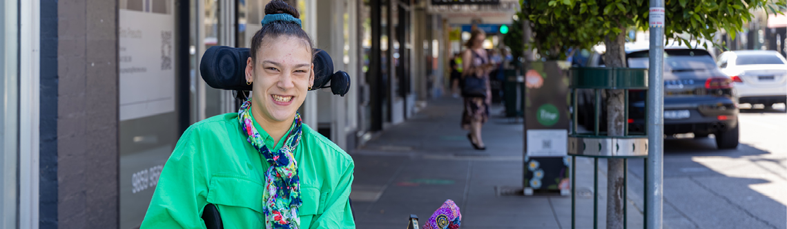 A young person in a wheelchair on a busy street