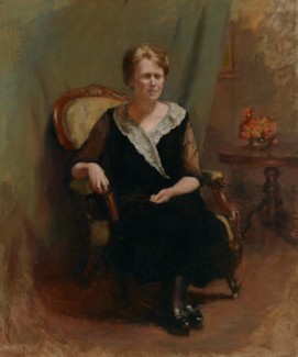 Woman in a black dress sitting in an armchair
