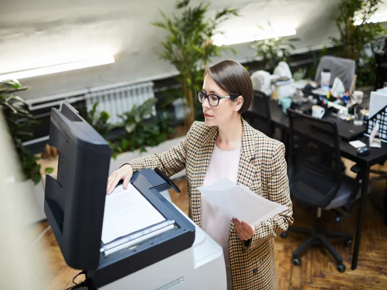 Woman loading paper in to a scanner