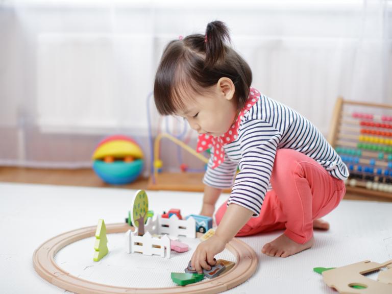 A toddler plays with a train set