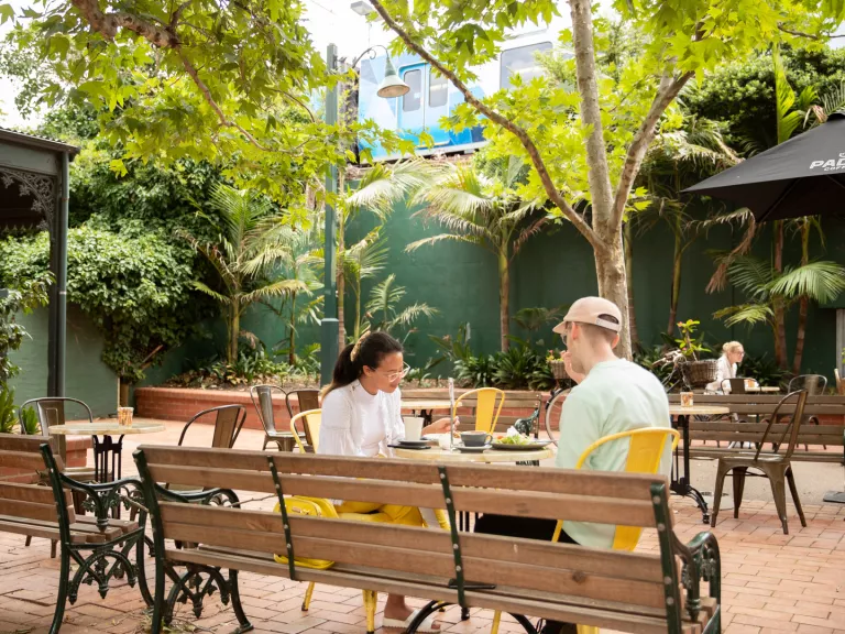 Two people sitting outside at a cafe.