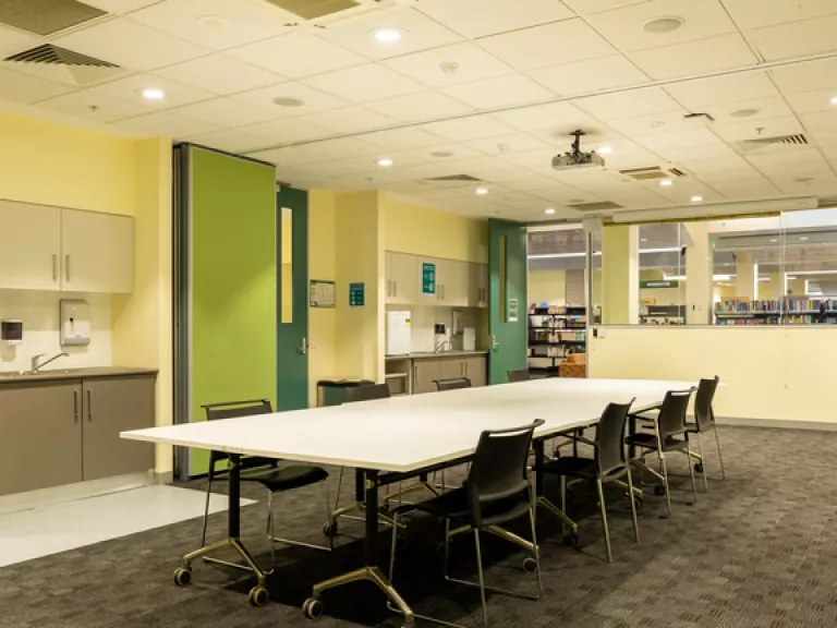 A meeting room with a boardroom table and bright green door