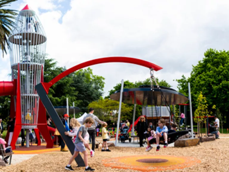 children's playground featuring a climbable red rocket ship