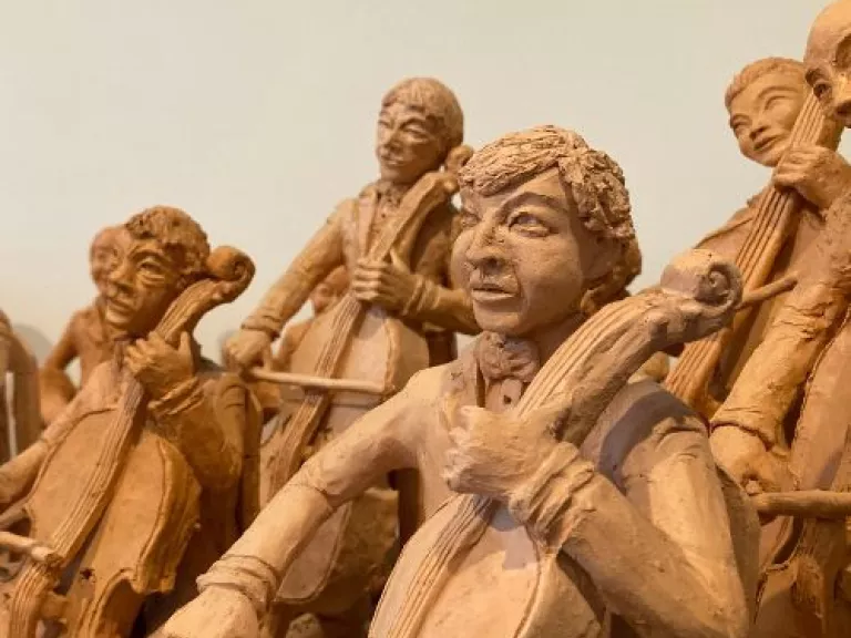 Woodcut statues of people playing string instruments