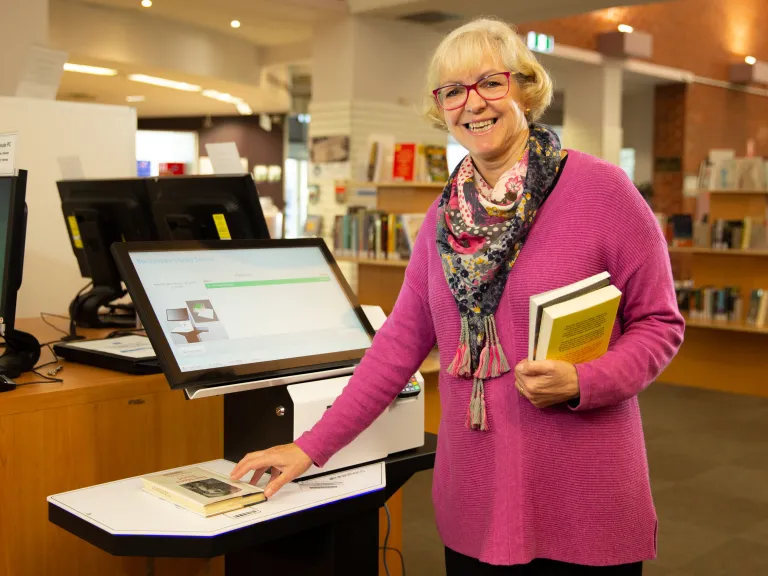 Library patron at self serve kiosk