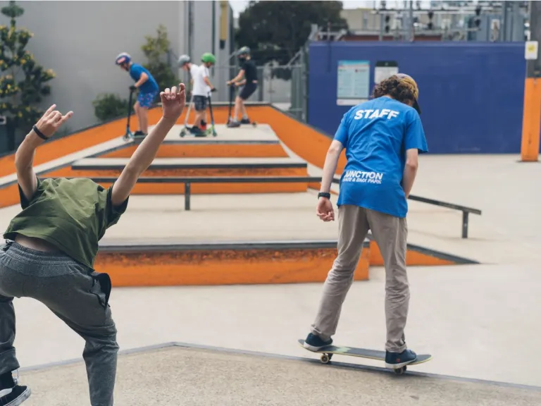 Two teenagers skateboarding in a skate park
