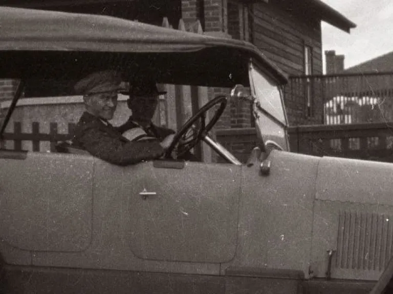 An old photo of a person in a car