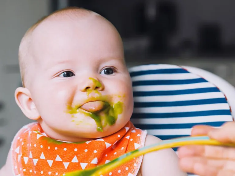  Baby in a high chair being fed