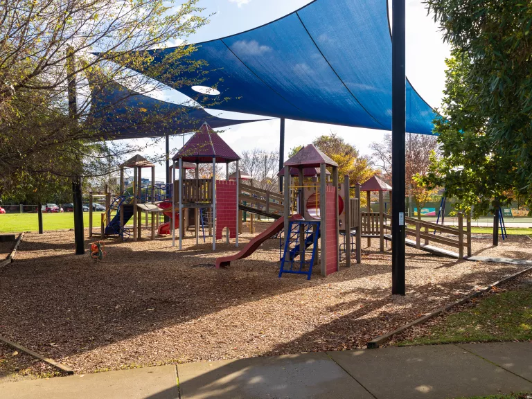 A playground for very young children with a large shade sail