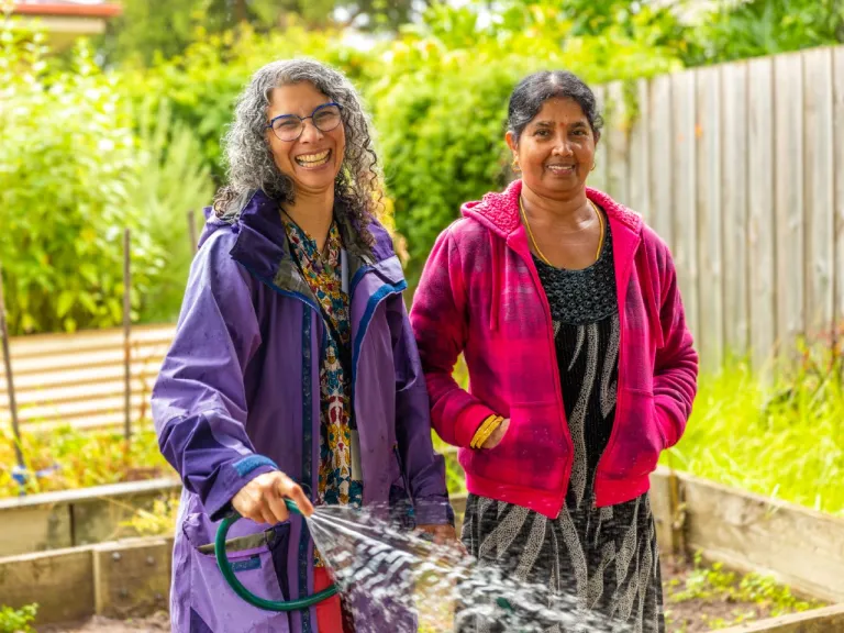 Two people watering a community garden