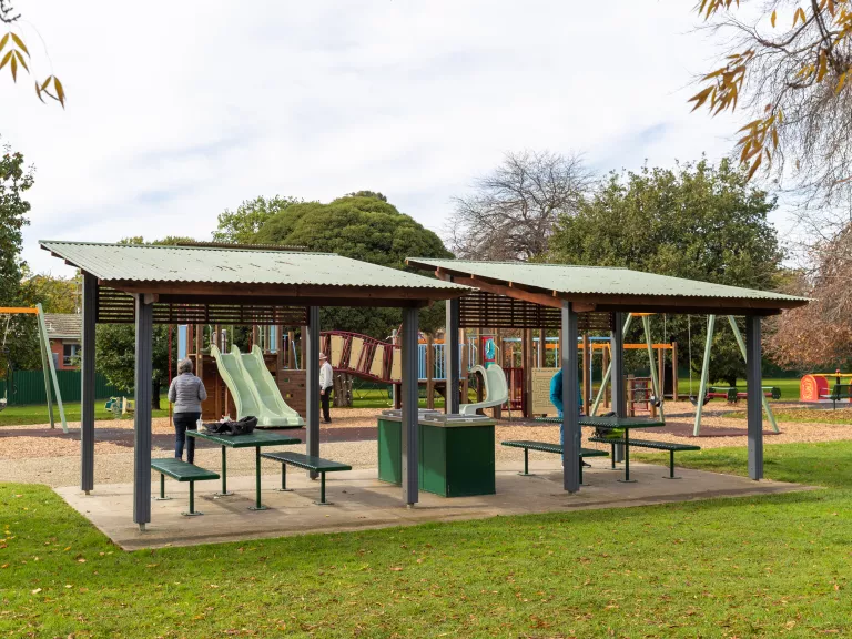 Barbecues under shelter next to a child's playground