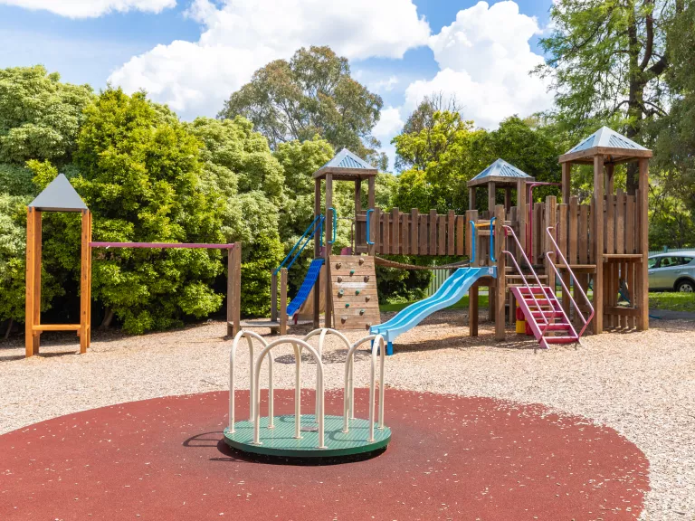 playground with a spinner and timber climbing structure