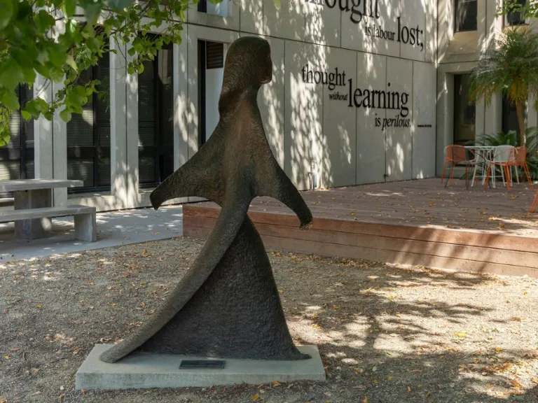 A life-size bronze figure of a woman in a long robe