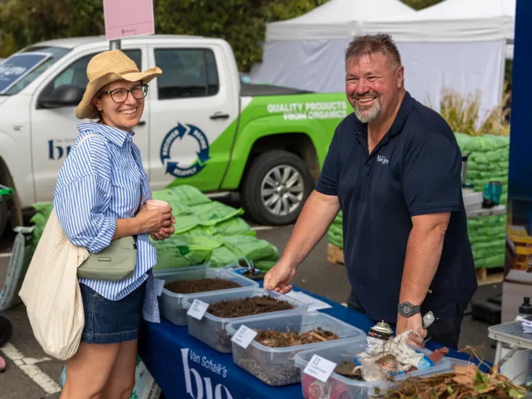 A woman buying fresh produce from a farmer at a market.