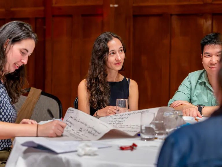 3 community members sit at a round table.