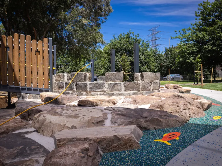 a rock-lined, water-play feature in a child's playground