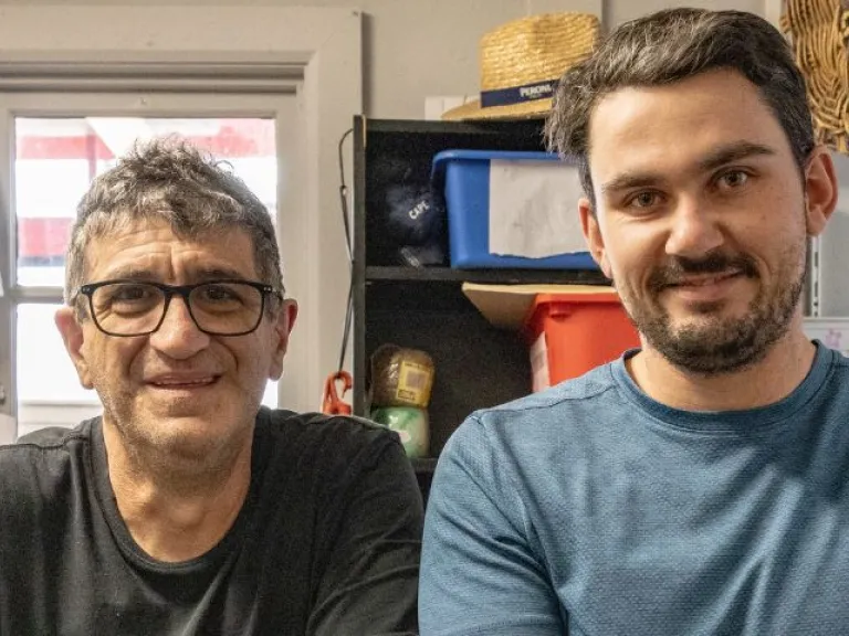 Two men standing at a work bench