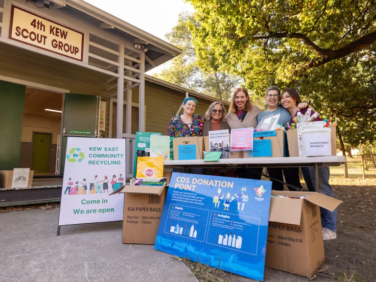 5 women stand behind a stall with a sign saying Kew East Community Recycling