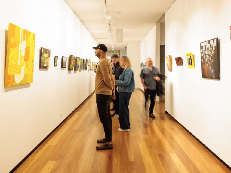 People looking at paintings on a wall