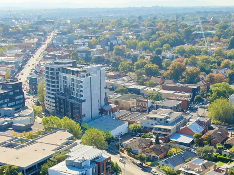 Arial view of a mix of houses, shops and multi floor buildings.